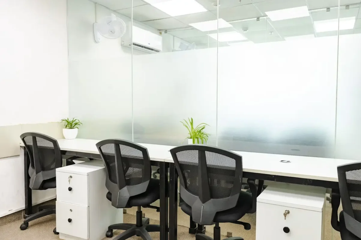 Vidrio esmerilado como divisor en una oficina moderna con luz natural